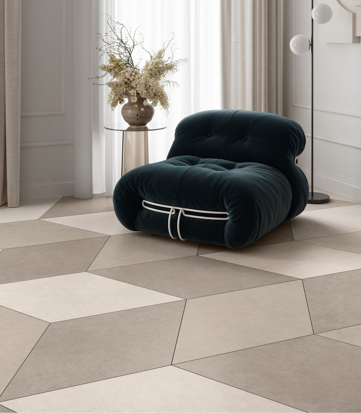 A modern tufted lounge chair in deep teal velvet with metal bracing, styled in a minimalist room with Plaster 2.0 Rhombus Shape tiles in Ivory, Sand, and Tortora, a side table with dried flowers, and a floor lamp.